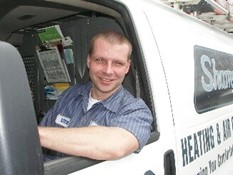 A Shamy HVAC technician smiling from his service truck. Shamy has the best technicians in Maumee. 